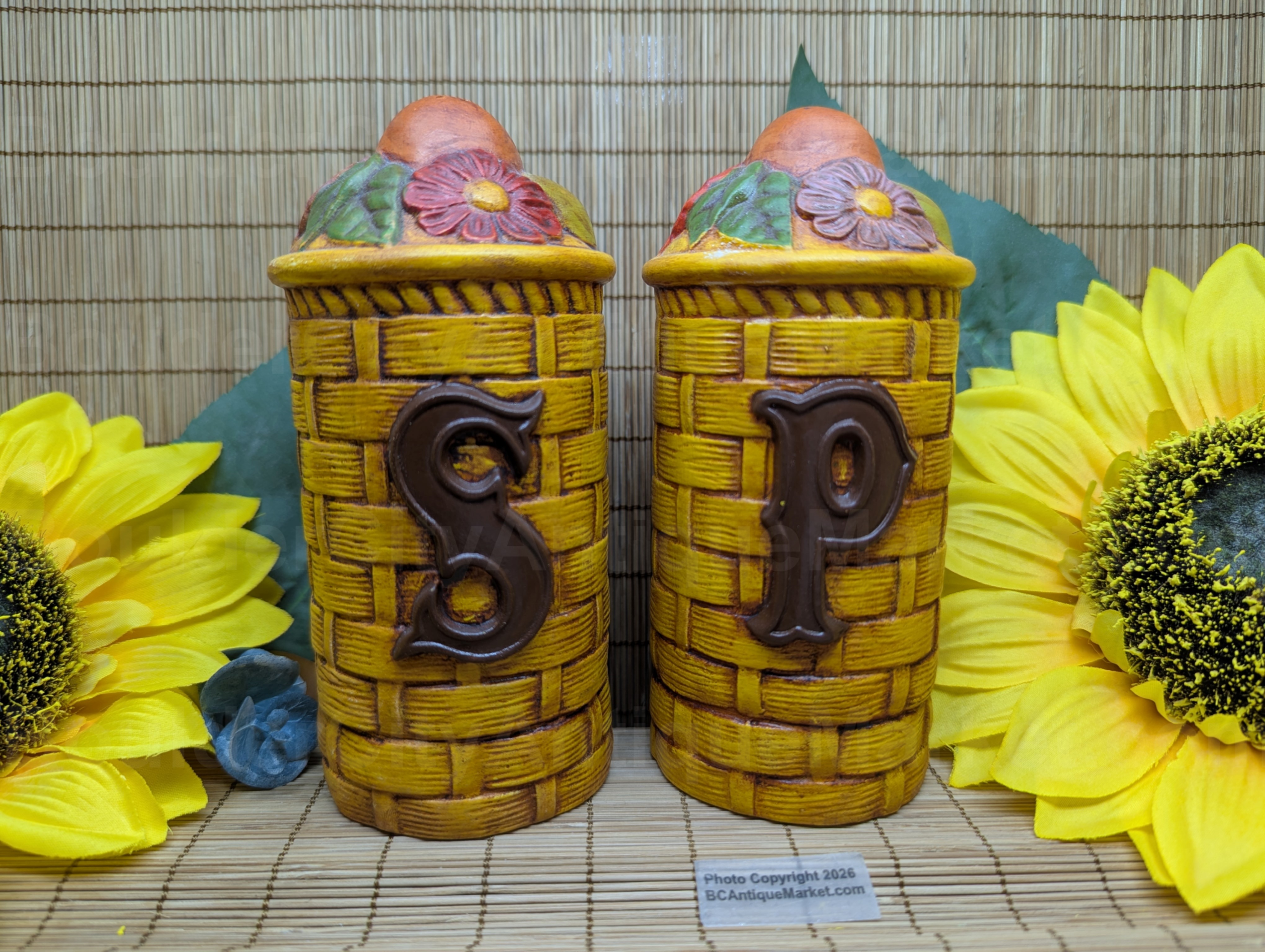 Vintage ceramic salt and pepper shakers, skillfully hand painted and have cork corks, likely dating from the 1950s-1970s. Detailed woven basket bases with fruit and floral top. Set is in excellent shape, no chips or marks. Stands just under 6 inches tall and 2.5 inches in diameter.