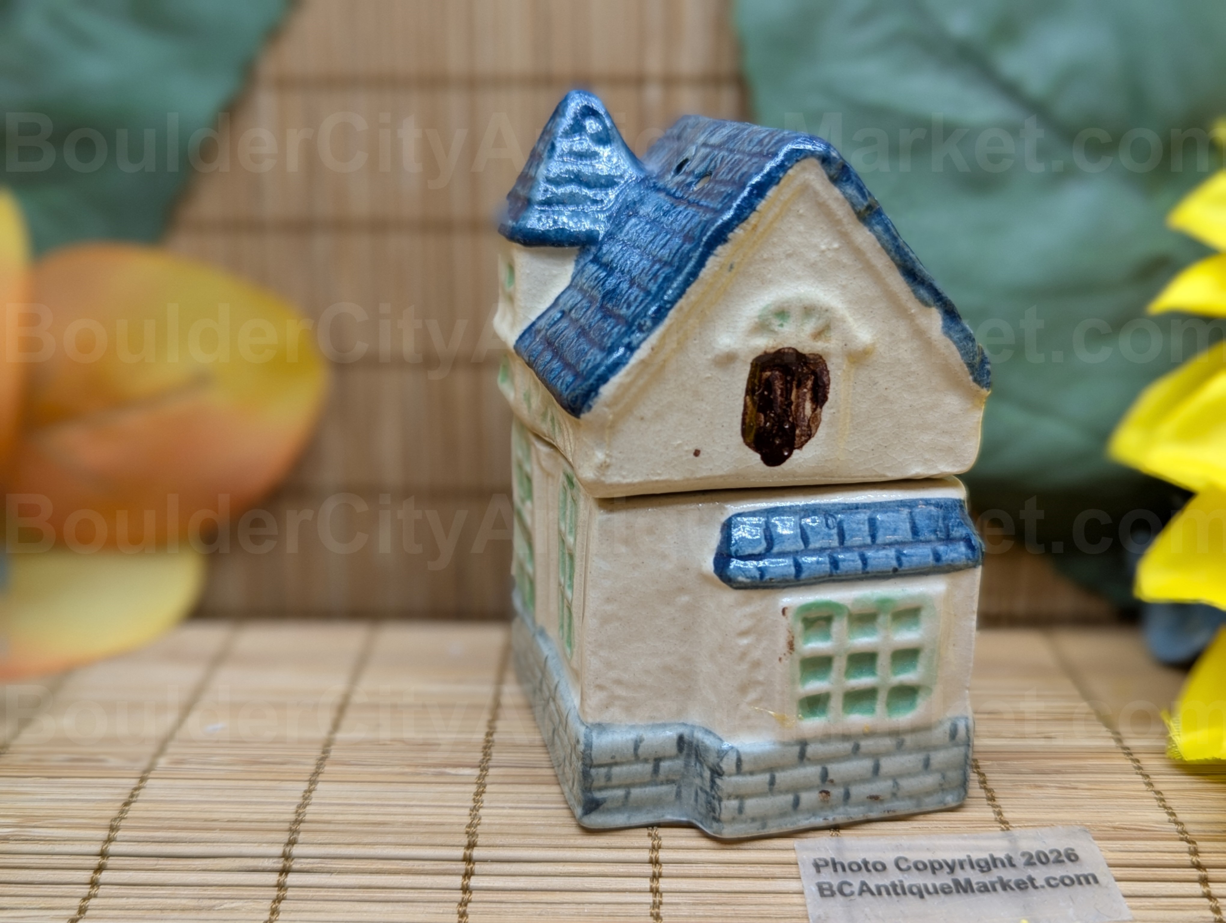 Blue roofed greenish and beige house salt and pepper set stands three inches tall when stacked.