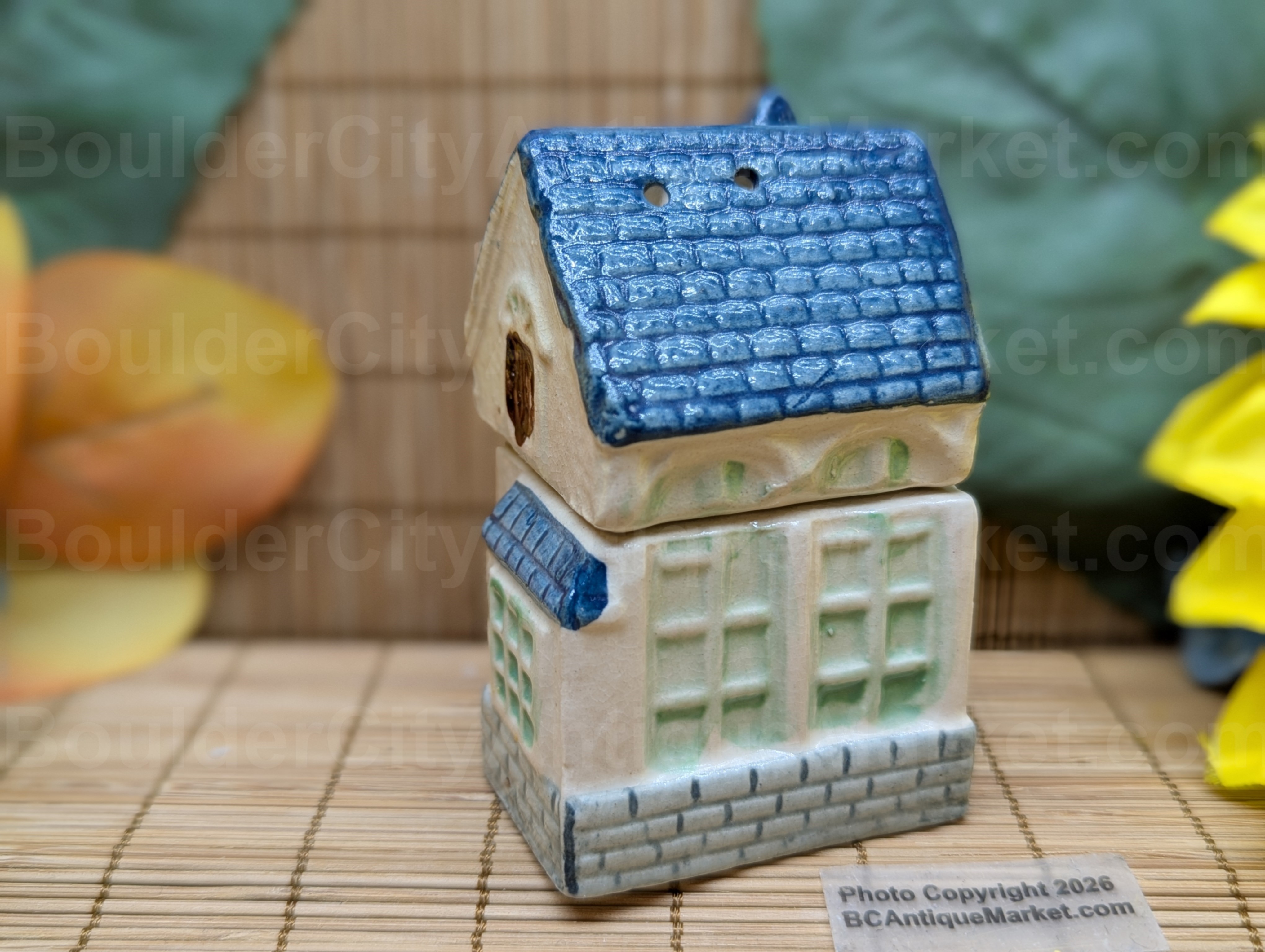 Blue roofed greenish and beige house salt and pepper set stands three inches tall when stacked.