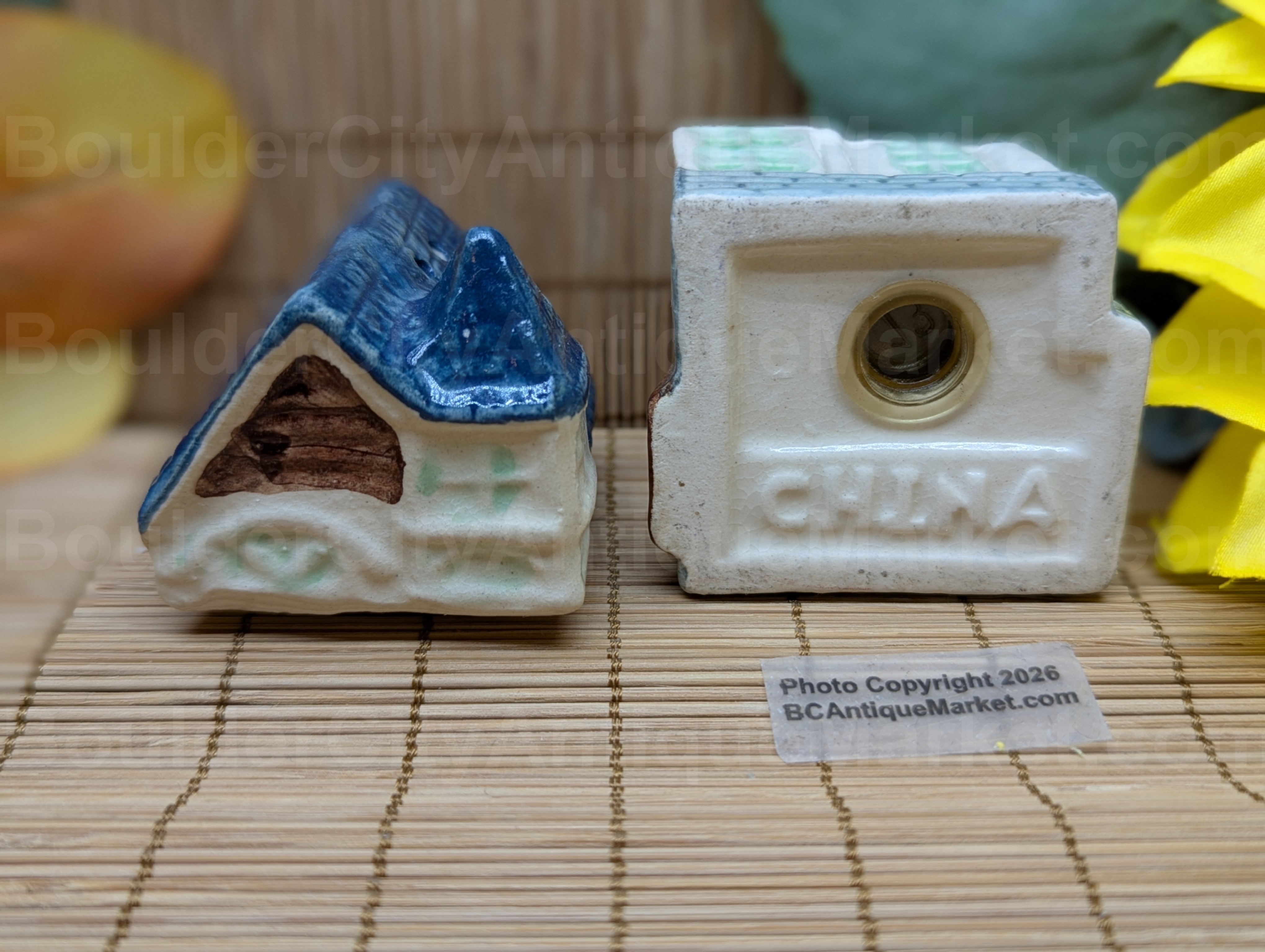 Blue roofed greenish and beige house salt and pepper set stands three inches tall when stacked.