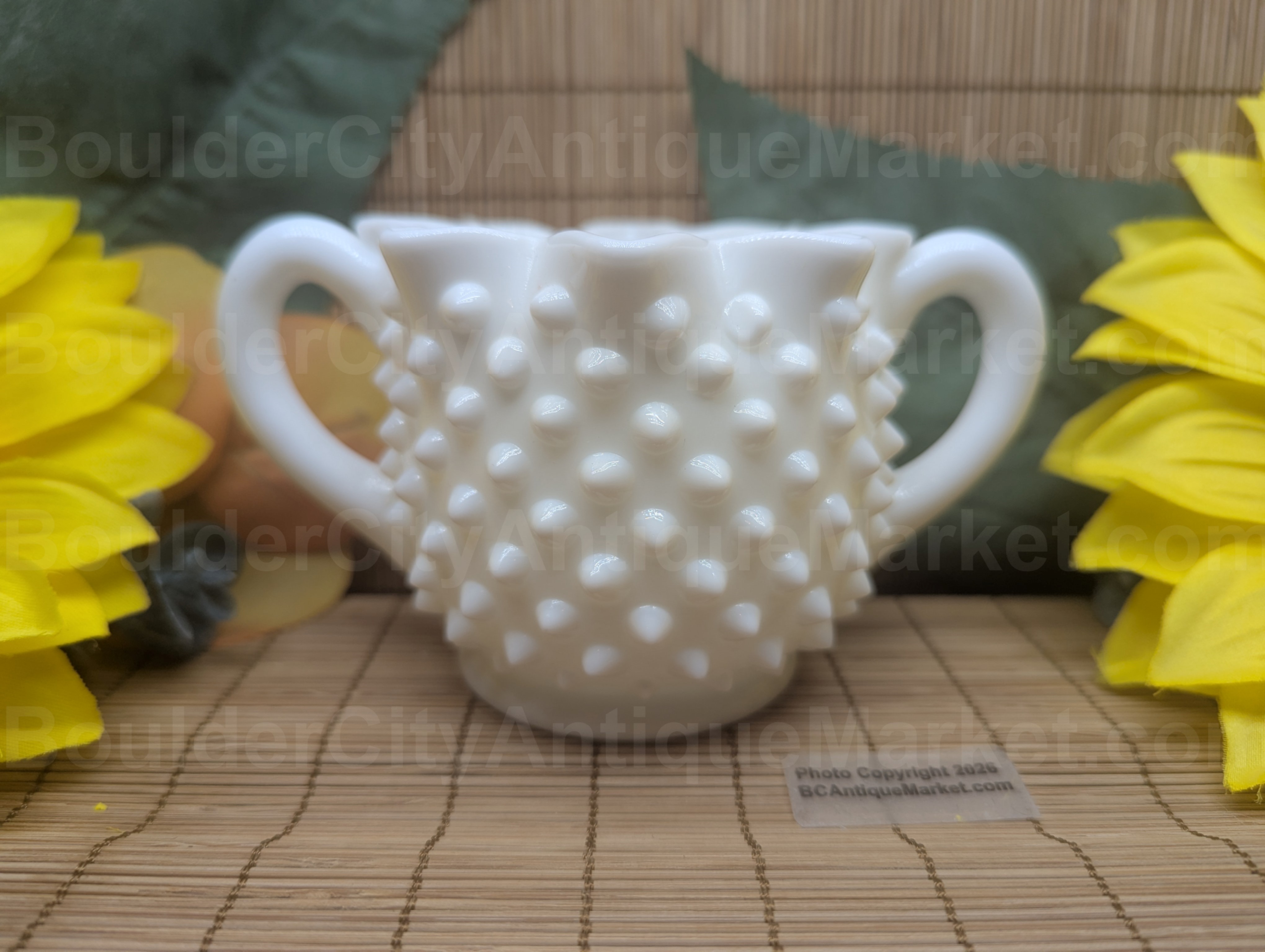 Hobnail creamer, thick milk glass, stands three inches tall and is five inches wide. No marks noted but this does show several signs of being an earlier, unstamped piece manufactured prior to the 1970s. Smooth bottom.