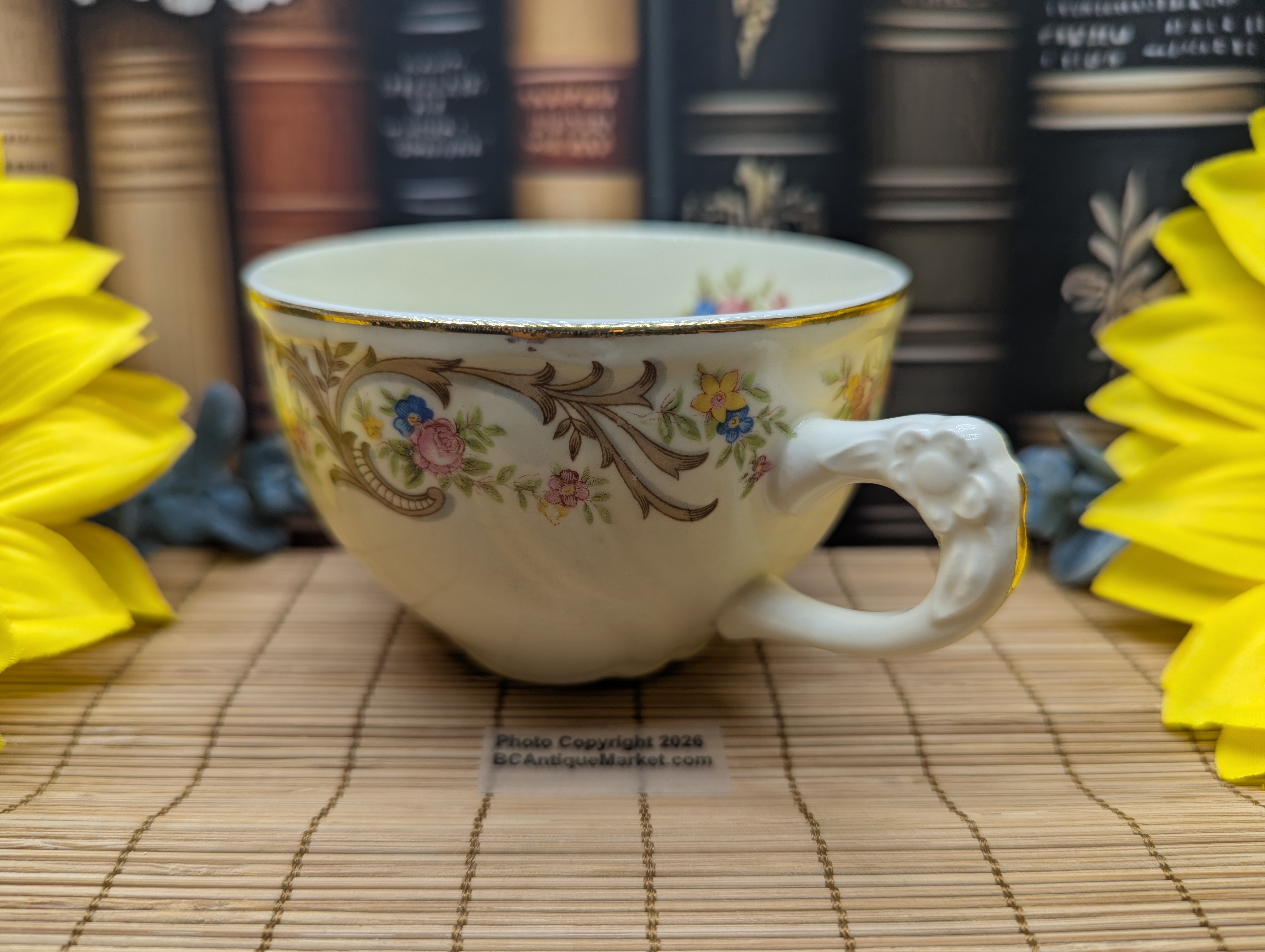 Taylor Smith Taylor teacup and saucer, detailed flower handle. Gold trim on the scalloped six-inch saucer and on the rim and handle of the 3.75-inch diameter teacup. The design number is 1631 and was manufactured around 1945 to 1955.