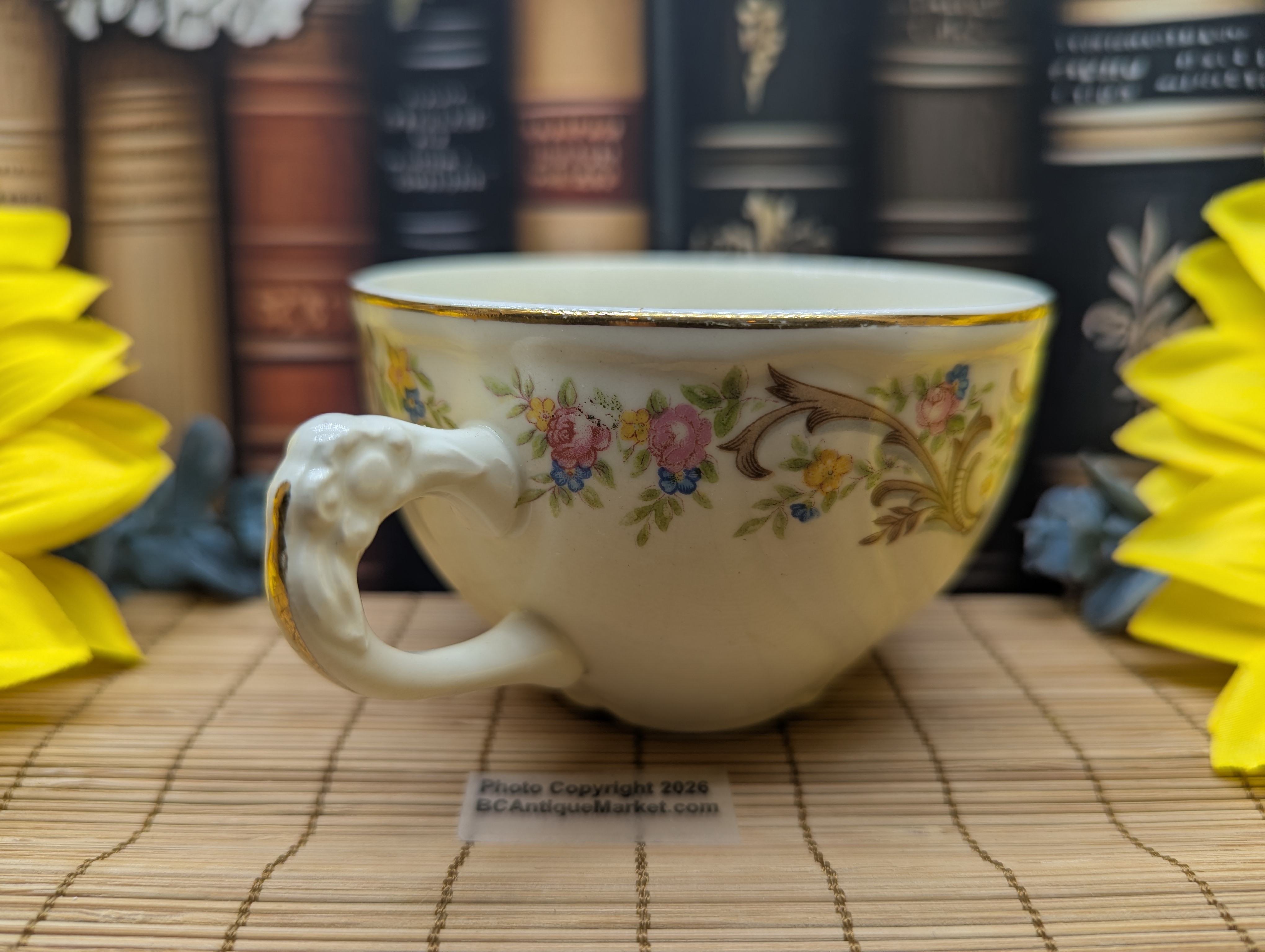 Taylor Smith Taylor teacup and saucer, detailed flower handle. Gold trim on the scalloped six-inch saucer and on the rim and handle of the 3.75-inch diameter teacup. The design number is 1631 and was manufactured around 1945 to 1955.